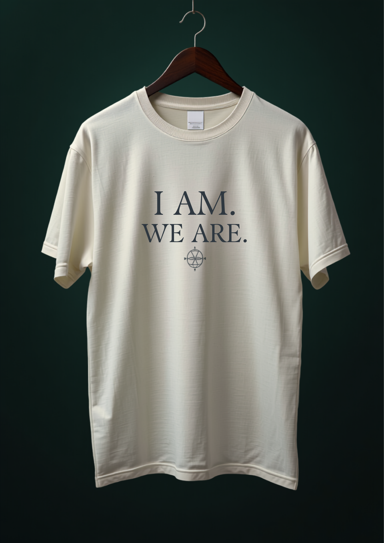 Cream T-shirt with I AM. WE ARE. in midnight blue serif type above a small flame-eye seal